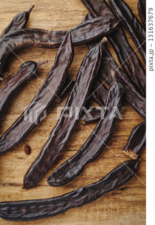 closeup of some ripe carob pods on a table closeup of some ripe carob pods on a table 131637679