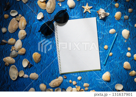 flat lay on blue background blank notebook copy space. summer plans concept 131637901