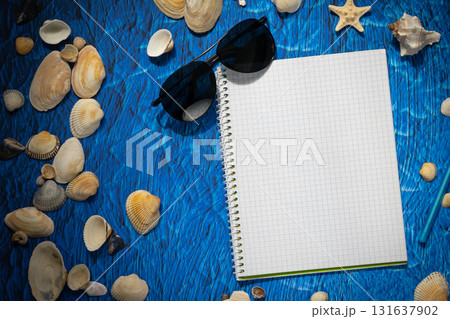 flat lay on blue background blank notebook copy space. summer plans concept 131637902