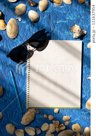 flat lay on blue background blank notebook copy space. summer plans concept 131637954