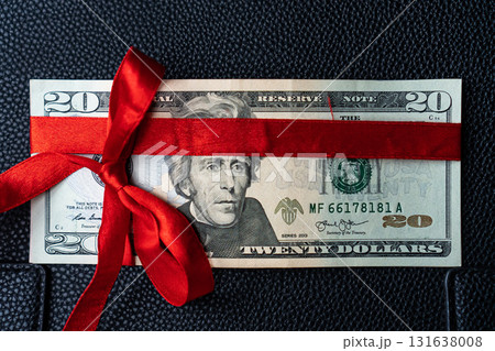 Money as a birthday present gift with red ribbon, dollar present Money as a birthday present gift with red ribbon, dollar present 131638008
