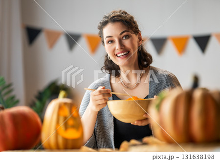 woman is carving pumpkin woman is carving pumpkin 131638198