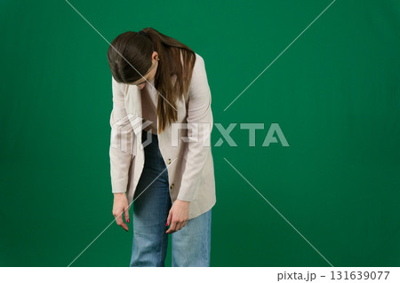 Set of photos of young European woman in light blazer and blue jeans showing various emotions gestures and expressions on green chroma key background with copy space for advertising and social media 131639077