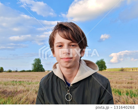 Happy teenage boy in nature in autumn. Portrait. Boy enjoying nature and going for a walk in the fresh air. 131640268