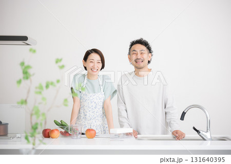 キッチンで笑顔のカメラ目線のミドル夫婦 131640395