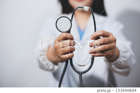 A young male doctor holding an stethoscope A young male doctor holding an stethoscope 131640684