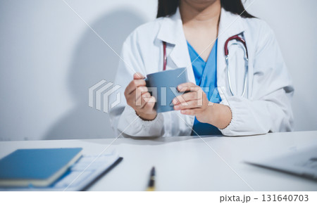 Female scientist holding coffee mug in laboratory Female scientist holding coffee mug in laboratory 131640703