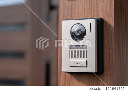 木目の門柱に取り付けられたモニター付きインターホン 131641525