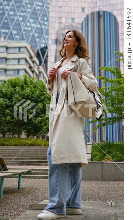 Woman in long coat modern city background 131641597