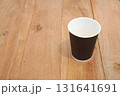 Modern brown cup mockup on light wooden table top 131641691