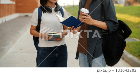 Happy students walking together on university campus, chatting and laughing outdoors after classes Happy students walking together on university campus, chatting and laughing outdoors after classes 131642202