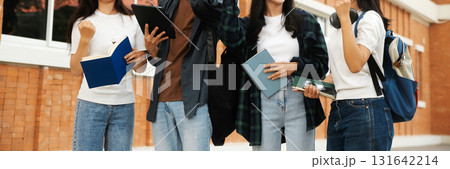 Happy students walking together on university campus, chatting and laughing outdoors after classes Happy students walking together on university campus, chatting and laughing outdoors after classes 131642214