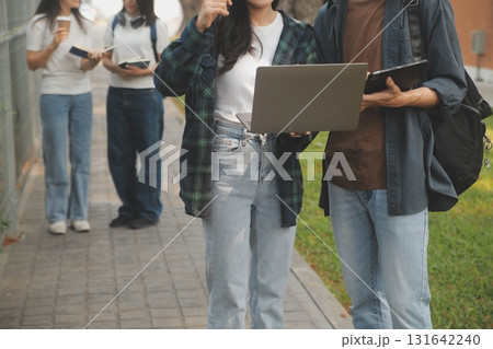 Happy students walking together on university campus, chatting and laughing outdoors after classes Happy students walking together on university campus, chatting and laughing outdoors after classes 131642240