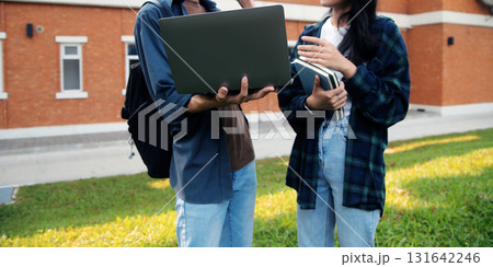 Happy students walking together on university campus, chatting and laughing outdoors after classes Happy students walking together on university campus, chatting and laughing outdoors after classes 131642246