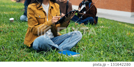 Happy students walking together on university campus, chatting and laughing outdoors after classes 131642280