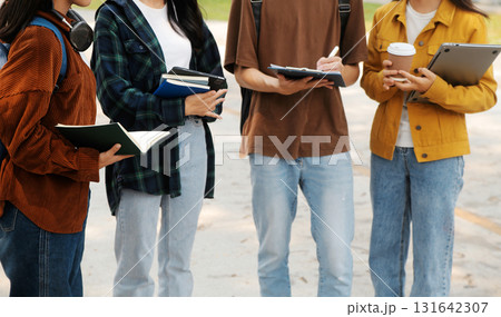 Happy students walking together on university campus, chatting and laughing outdoors after classes Happy students walking together on university campus, chatting and laughing outdoors after classes 131642307