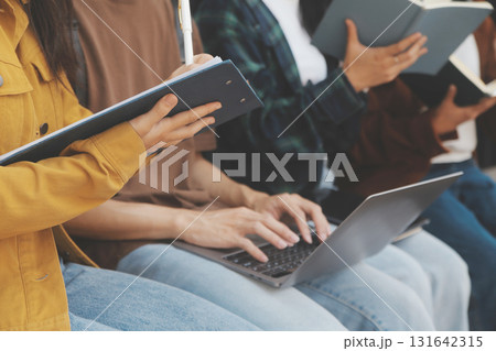 Happy students walking together on university campus, chatting and laughing outdoors after classes 131642315