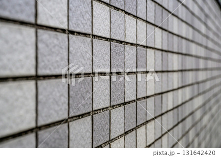 グレーのモザイクタイル壁｜幾何学模様が美しい建築テクスチャの背景素材 131642420
