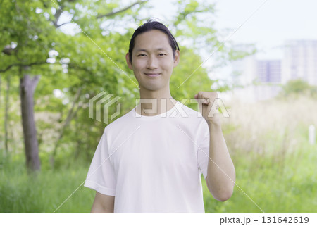 公園に立つガッツポーズをする若い男性のポートレート 131642619