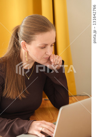 Young woman working on laptop in home environment Young woman working on laptop in home environment 131642766