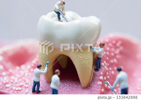 Miniature doctors treat a giant tooth in a dental clinic setup for educational purposes 131642898