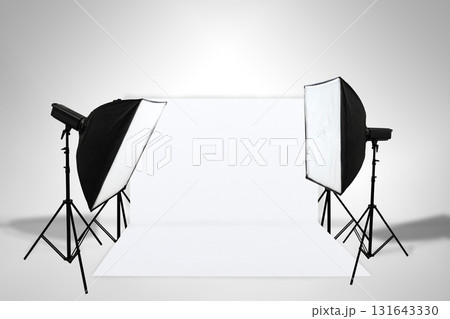 Minimalist studio lighting setup with softbox lights, stands, and a white backdrop. Copy space. Product shooting, e-commerce, portrait, and general studio. Professional setup for showcasing products 131643330