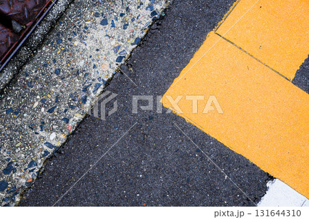 道路の黄色いラインとアスファルトの質感｜都市の舗装と標示の抽象テクスチャ 131644310