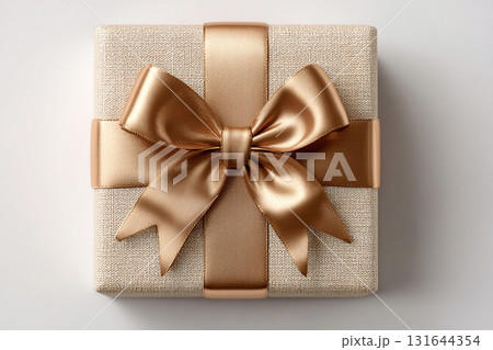 Birthday gift. Top view. Elegant square gold box wrapped with a silver bow on white background. Jewelry, birthdays and luxury branding. 131644354