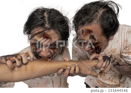 Portrait of two Indonesian southeast asian scary male zombies with wounds and blood trying to eat a human hand isolated over a white background. Spooky expression. Concept of Halloween or Horror Portrait of two Indonesian southeast asian scary male zombies with wounds and blood trying to eat a human hand isolated over a white background. Spooky expression. Concept of Halloween or Horror 131644548