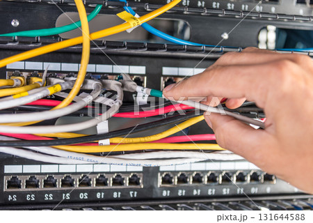 hand of engineer plugging in ethernet cable into server switch p 131644588