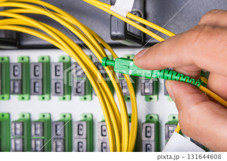 hand of engineer plugging in ethernet cable into server switch p 131644608