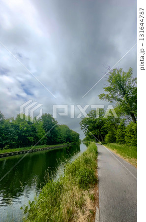 A Serene and Winding Waterside Path Surrounded by Lush Greenery and Idyllic Landscape A Serene and Winding Waterside Path Surrounded by Lush Greenery and Idyllic Landscape 131644787