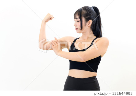 体を鍛えてるかっこいい女性　力こぶをつくる　筋トレ女子　スポーツブラ　白バック　 131644993