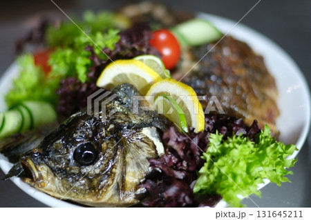 stuffed fish Delicious stuffed carp with lemon and lettuce leaves. stuffed fish Delicious stuffed carp with lemon and lettuce leaves. 131645211