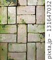 Old brick pavement covered with moss and weather stains 131647032