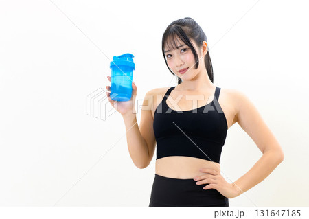 プロテインシェイカーを持つ、体を鍛えてるかっこいい女性　筋トレ女子　白バック　トリミングアップ左余白 131647185