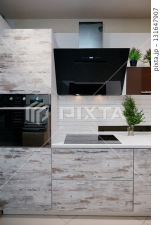 A trendy kitchen with white countertops, an induction hob, and spotlights A trendy kitchen with white countertops, an induction hob, and spotlights 131647907