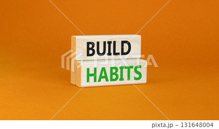 Build habits symbol. Concept word Build habits on beautiful wooden blocks. Beautiful orange paper background. Business build habits concept. Copy space. 131648004