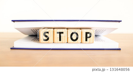 Stop symbol. Concept word Stop on beautiful wooden blocks in book. Beautiful wooden table white background. Business, lifestyle, support and stop concept. Copy space. 131648056