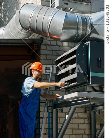 Engineer tightening bolts on large industrial ventilation system Engineer tightening bolts on large industrial ventilation system 131648303