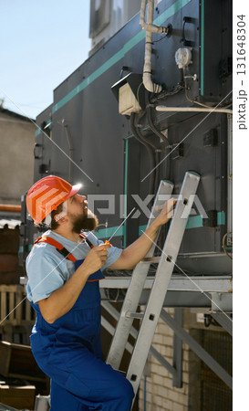 Technician repairing industrial ventilation unit with tools 131648304