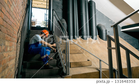 Engineer resting on stairs after technical inspection work Engineer resting on stairs after technical inspection work 131648358