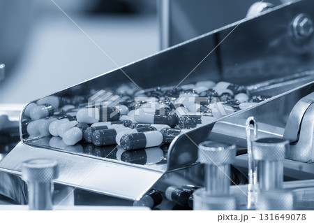 Close up scene the capsules drug mass production process in the light blue scene. 131649078
