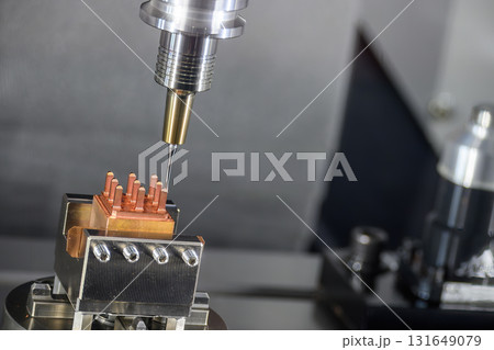 Close up scene the CNC milling machine cutting the copper electrode parts. Close up scene the CNC milling machine cutting the copper electrode parts. 131649079