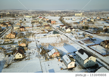 Aerial view of residential houses with snow covered roofops in suburban rural town area in winter Aerial view of residential houses with snow covered roofops in suburban rural town area in winter 131649808