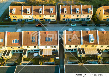 Aerial view of residential houses with red roofs and streets with parked cars in rural town area. Quiet suburbs of a modern european city. 131649809