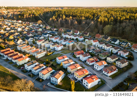 Aerial view of residential houses with red roofs and streets with parked cars in rural town area. Quiet suburbs of a modern european city. 131649821