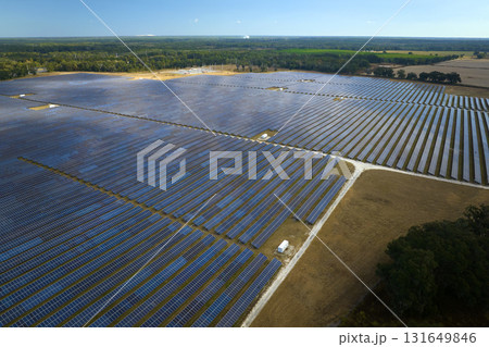 Aerial view of large sustainable electrical power plant with rows of solar photovoltaic panels for producing clean electric energy. Concept of renewable electricity with zero emission Aerial view of large sustainable electrical power plant with rows of solar photovoltaic panels for producing clean electric energy. Concept of renewable electricity with zero emission 131649846