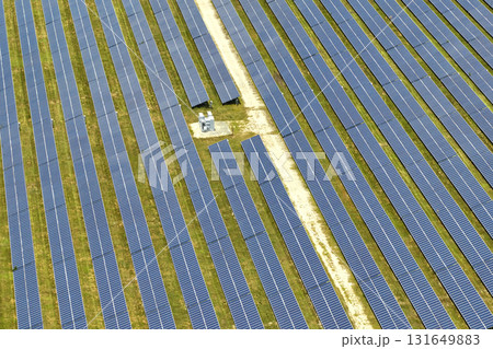 Aerial view of large sustainable electrical power plant with rows of solar photovoltaic panels for producing clean electric energy. Concept of renewable electricity with zero emission Aerial view of large sustainable electrical power plant with rows of solar photovoltaic panels for producing clean electric energy. Concept of renewable electricity with zero emission 131649883
