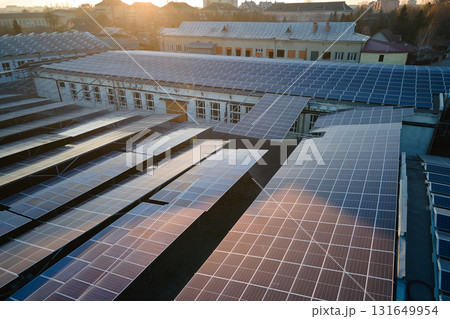 Aerial view of blue photovoltaic solar panels mounted on industrial building roof for producing green ecological electricity. Production of sustainable energy concept 131649954